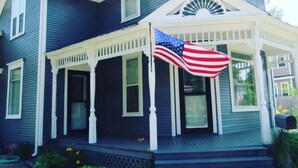 A two-story house with a porch, a front door, and a small set of steps leading to the entrance. - Riverwalk Retreat on Main. Spacious updated Victorian Home in the heart of Niles (Niles)
