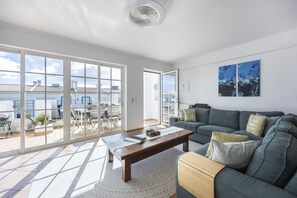 A spacious living room with a large sliding glass door leading to an outdoor patio area.