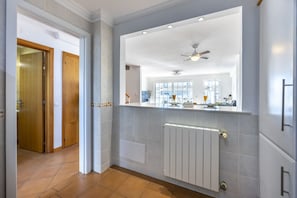 A modern kitchen with a large window, a ceiling fan, and a built-in oven.