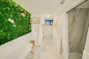 A bathroom with a green wall, white tiles, a shower, and a toilet.