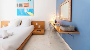 Ein Hotelzimmer mit einem Bett, einem Nachttisch mit Lampe, einem Spiegel und einem Wandbild.