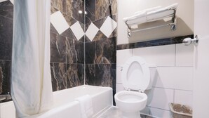 A modern bathroom with a bathtub, toilet, and shower. - Palace Inn I10East & John Ralston (Houston)
