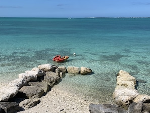 Visão nítida de uma costa rochosa com um caiaque amarrado às pedras.
