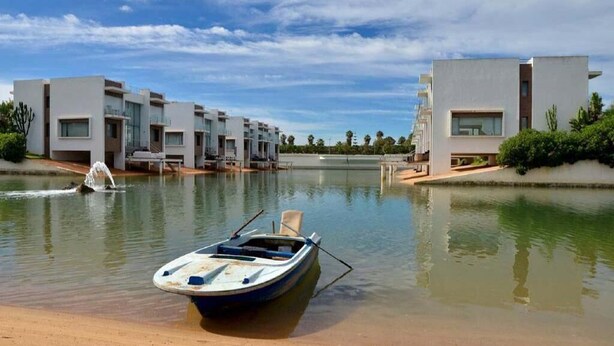 Un hotel moderno con piscina y un barco.
