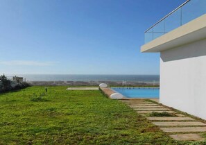 A modern building with a pool and a view of the sea.