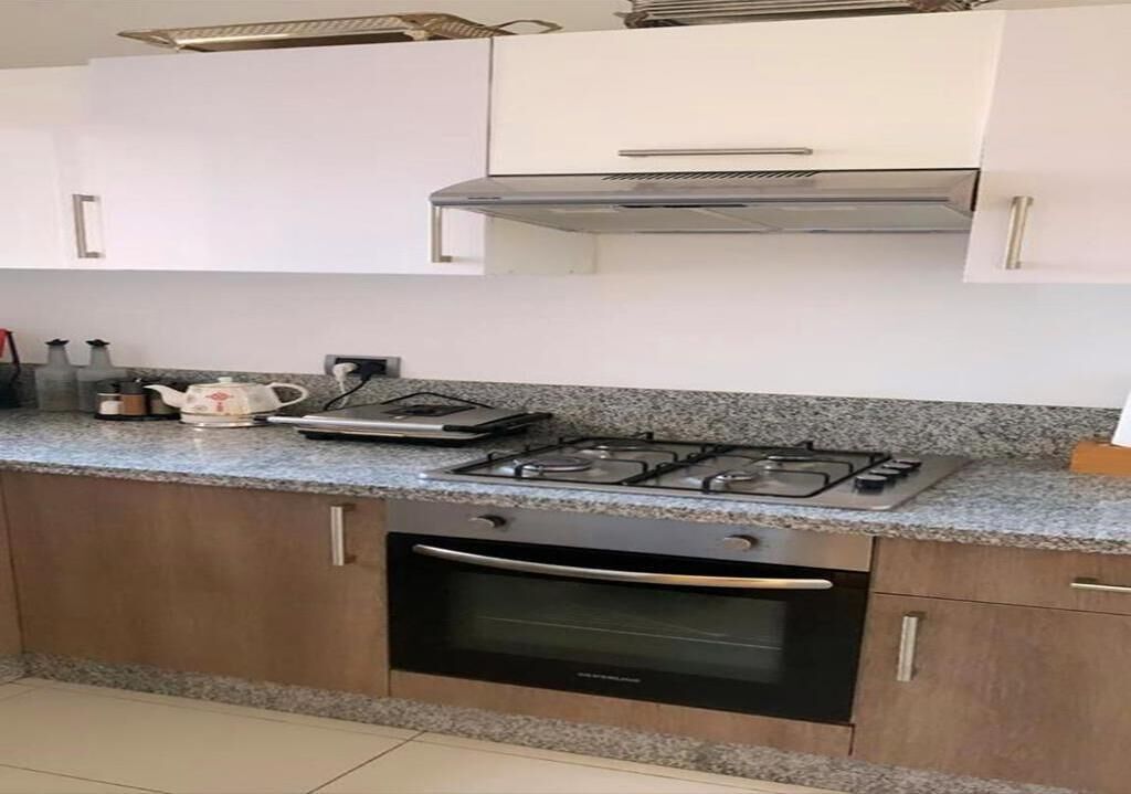 A kitchen with a gas stove, oven, and granite countertop.