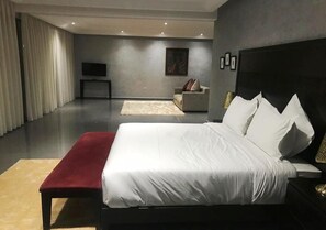 A modern bedroom with a large bed, a bedside table, a TV, and a sofa. - Spacious Villa with swimming pool in Marrakech 5230 (Marrakech)