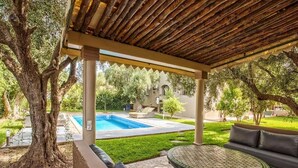 A covered outdoor area with a pool, a round table, and a sofa. - High standing villa with swimming pool 5231 (Marrakech)