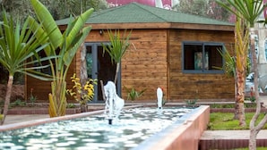 A wooden cabin with a small pond and tropical plants. - Pleasant apartment in Premium Village Marrakech 5239 (Marrakech)