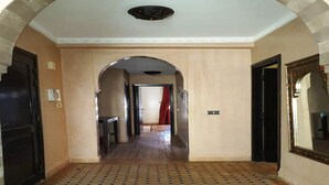 A hallway with patterned flooring, an arched doorway, and a mirror on the right wall. - Pleasant apartment in Premium Village Marrakech 5239 (Marrakech)