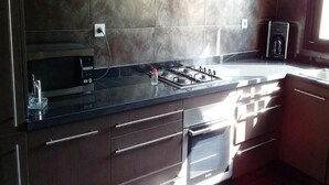 Una cocina moderna con estufa a gas, microondas y horno.