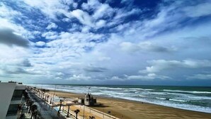 Une plage avec un ciel dégagé et des vagues.