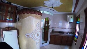 A compact kitchen with a refrigerator, a sink, and a cabinet. - Duplex in Chefchaouen 5264 (Chefchaouen)