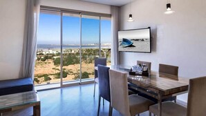 A modern hotel room with a large window offering a view of the beach and cityscape. - Splendid Sea View Apartment in Essaouira 5274 (Essaouira)