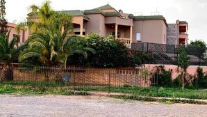 A multi-story building with a green roof, surrounded by a fence and greenery. - Pleasant Villa with pool Route Targa Marrakech 5282 (Marrakech)