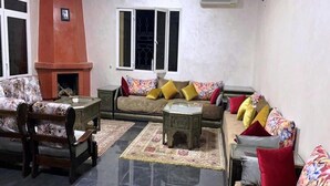 A living room with a sofa set, a coffee table, and a fireplace. - Pleasant Villa with pool Route Targa Marrakech 5282 (Marrakech)