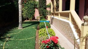 A garden with a lawn, a pathway, and a building with a balcony. - Pleasant Villa with pool Route Targa Marrakech 5282 (Marrakech)