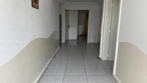 A hallway with white walls and grey tiled flooring. - Floor villa in Sidi Bouzid 5283 (Sidi Bouzid)