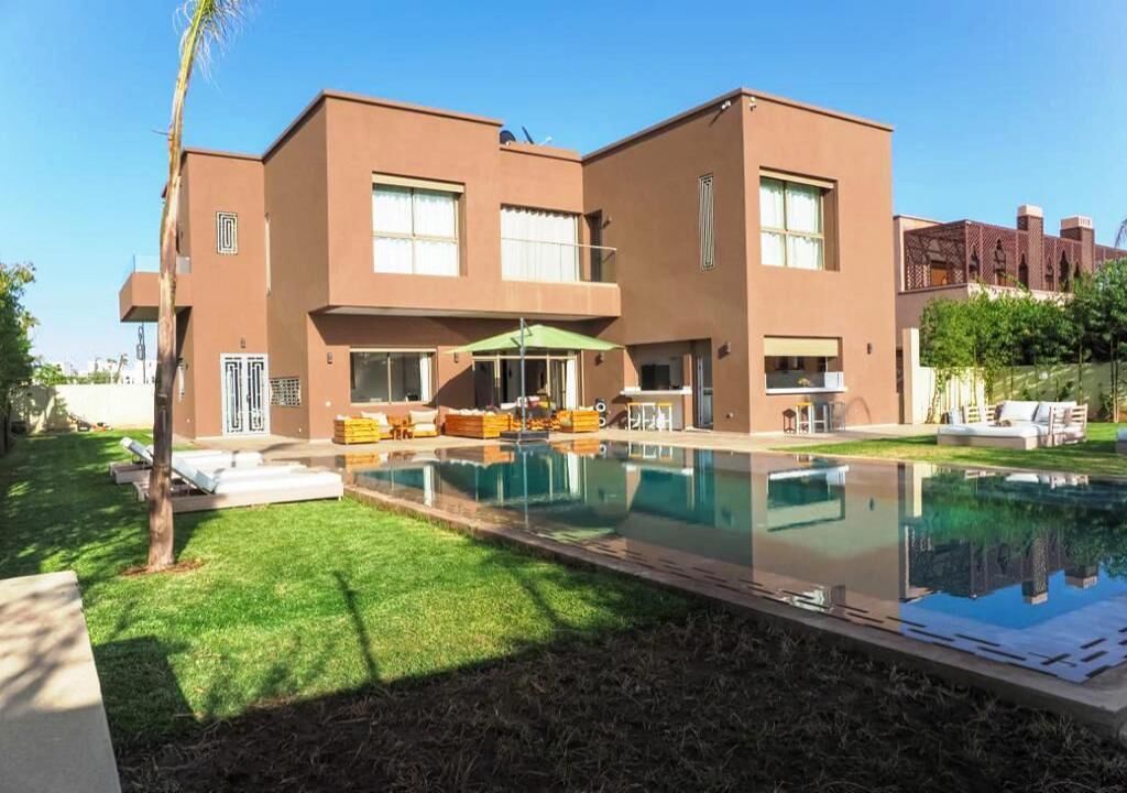 A modern two-story building with a swimming pool in front.