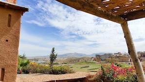 A rustic building with a wooden pergola, a view of a hilly landscape, and a distant cityscape. - DAR BOUMIDA 5289 Lalla Takerkoust (Lalla Takerkoust)
