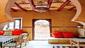 A traditional interior with a wooden ceiling, a central archway, and a seating area with cushions. - DAR BOUMIDA 5292 Lalla Takerkoust (Lalla Takerkoust)