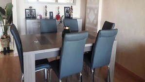 A dining area with a rectangular table, four chairs, and a decorative vase. - Superb apartment in Prestigia Marrakech 5315 (Marrakech)