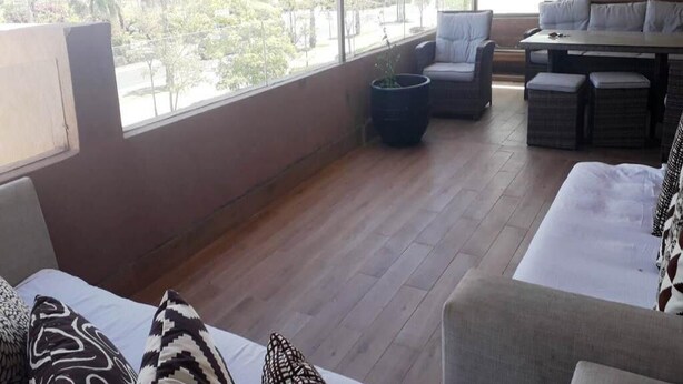 A modern room with a large window, a sofa, a dining table, and a chair. - Superb apartment in Prestigia Marrakech 5315 (Marrakech)