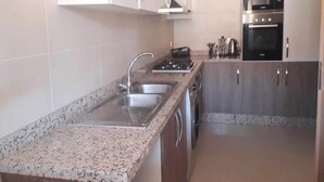 A kitchen with granite countertops, stainless steel appliances, and wooden cabinets. - Superb apartment in Prestigia Marrakech 5315 (Marrakech)