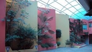 A building facade with numbered sections 26, 29, and 30, and a covered outdoor area with a glass ceiling. - Hotel Pal (Mexico City)