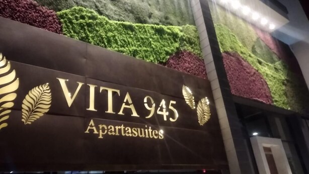 A hotel sign with the name "VITA 945 Apartasuites" and decorative golden leaf motifs. - Cozy Apartment with Ocean View from balcony (Gaira)