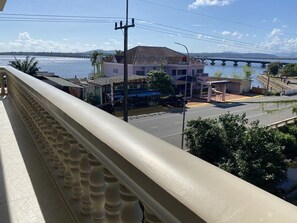 Un balcon avec vue sur une rivière et un pont.