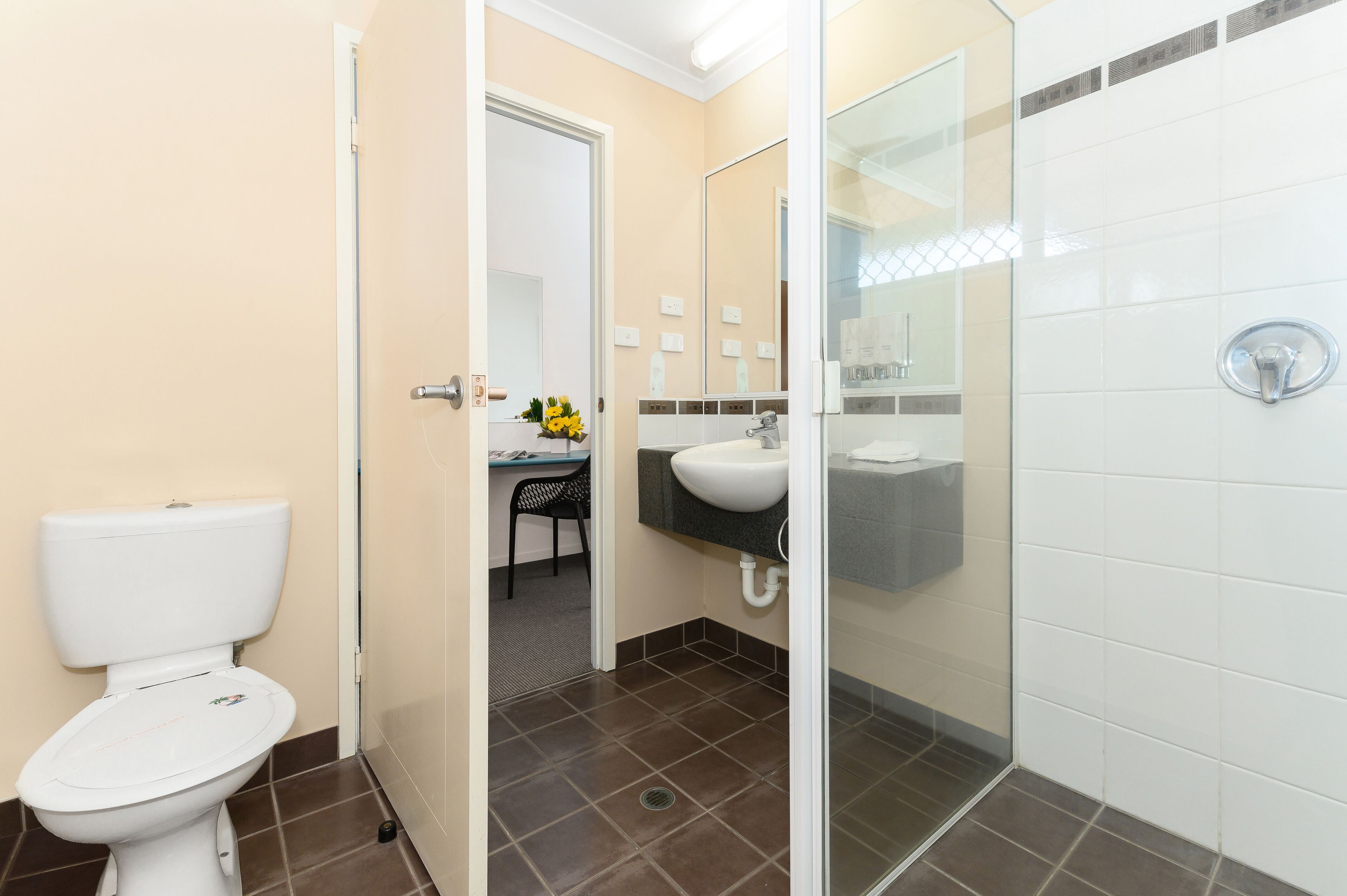 A bathroom with a toilet, sink, and shower area.