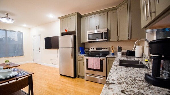 Fully equipped kitchen with refrigerator, microwave, oven, and coffee maker.
