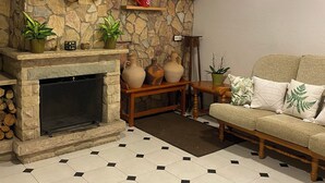 A living room with a stone wall, fireplace, and a sofa.
