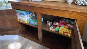 Una estantería de madera con varios juegos de mesa y un letrero que dice "LAKE".