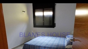 Een slaapkamer met een bed, een raam en een deur.