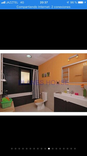 Bathroom features a vanity, sink, toilet, and shower area.