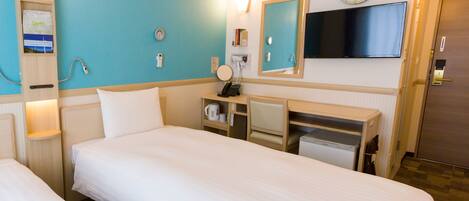 A hotel room with two beds, a desk, a mirror, a clock, and an air conditioning unit.