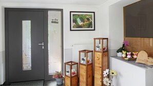 A modern interior with a dark door, a framed landscape painting, and a shelf with decorative items. - Apartment 'Bergglück' with Mountain View, Balcony and Wi-Fi (See)
