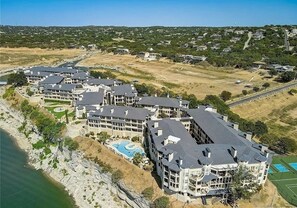 A coastal hotel with multiple buildings, a swimming pool, and a tennis court. - Peaceful Getaway at Island of Lake Travis- Beautifully decorated- Huge patio! (Lago Vista)
