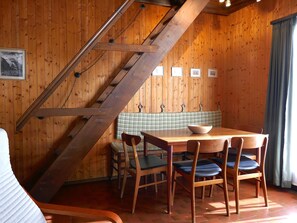 A wooden interior with a staircase, a dining table with chairs, and a bench. - Chalet Al Portic by Interhome (Olivone)