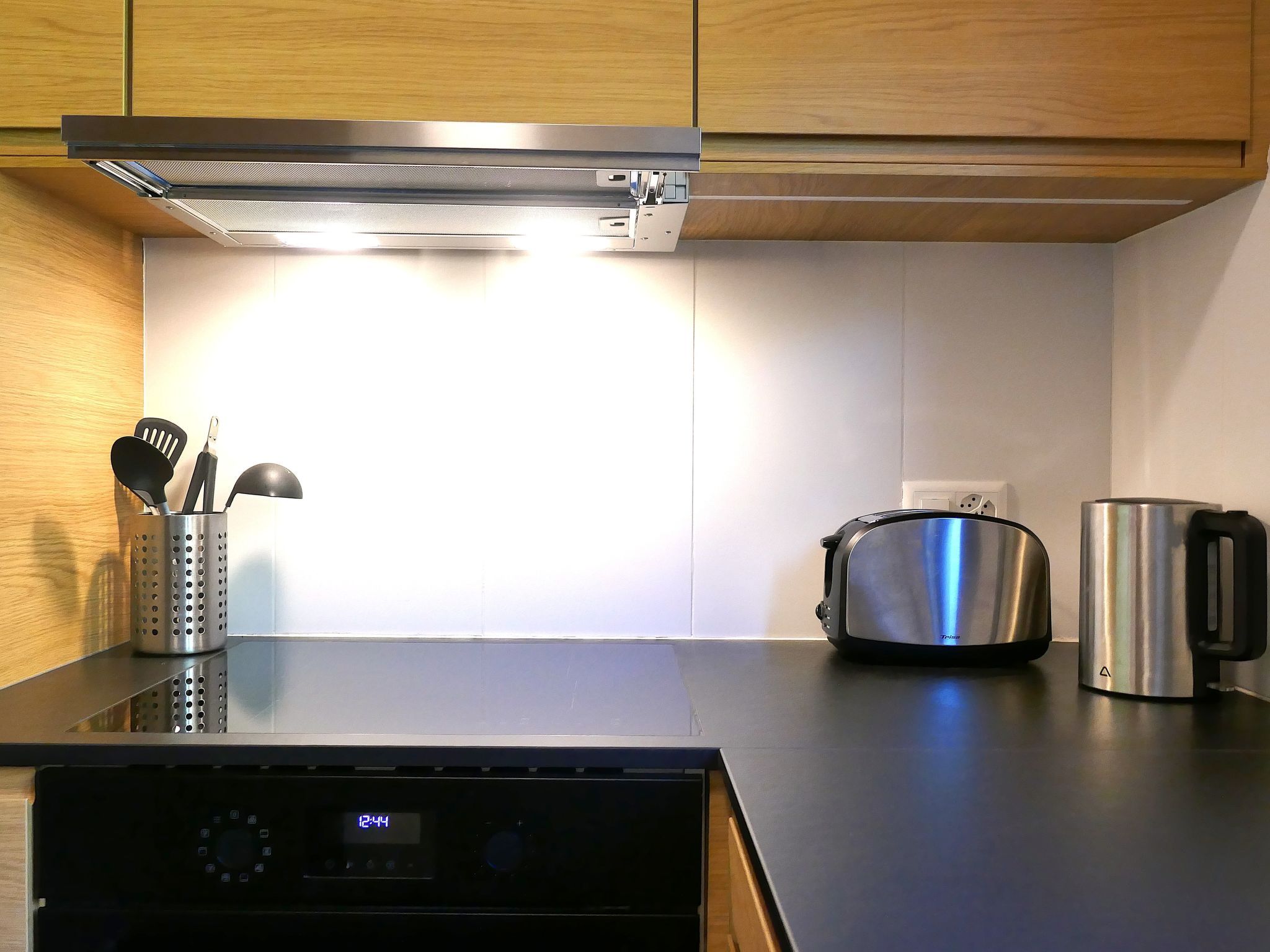 Eine Küche mit einem Herd, einem Toaster und einem Wasserkocher auf der Arbeitsfläche.