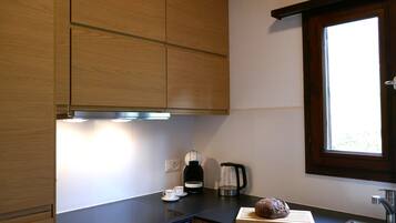 A modern kitchen with wooden cabinets, a black countertop, a window, and a stainless steel sink.