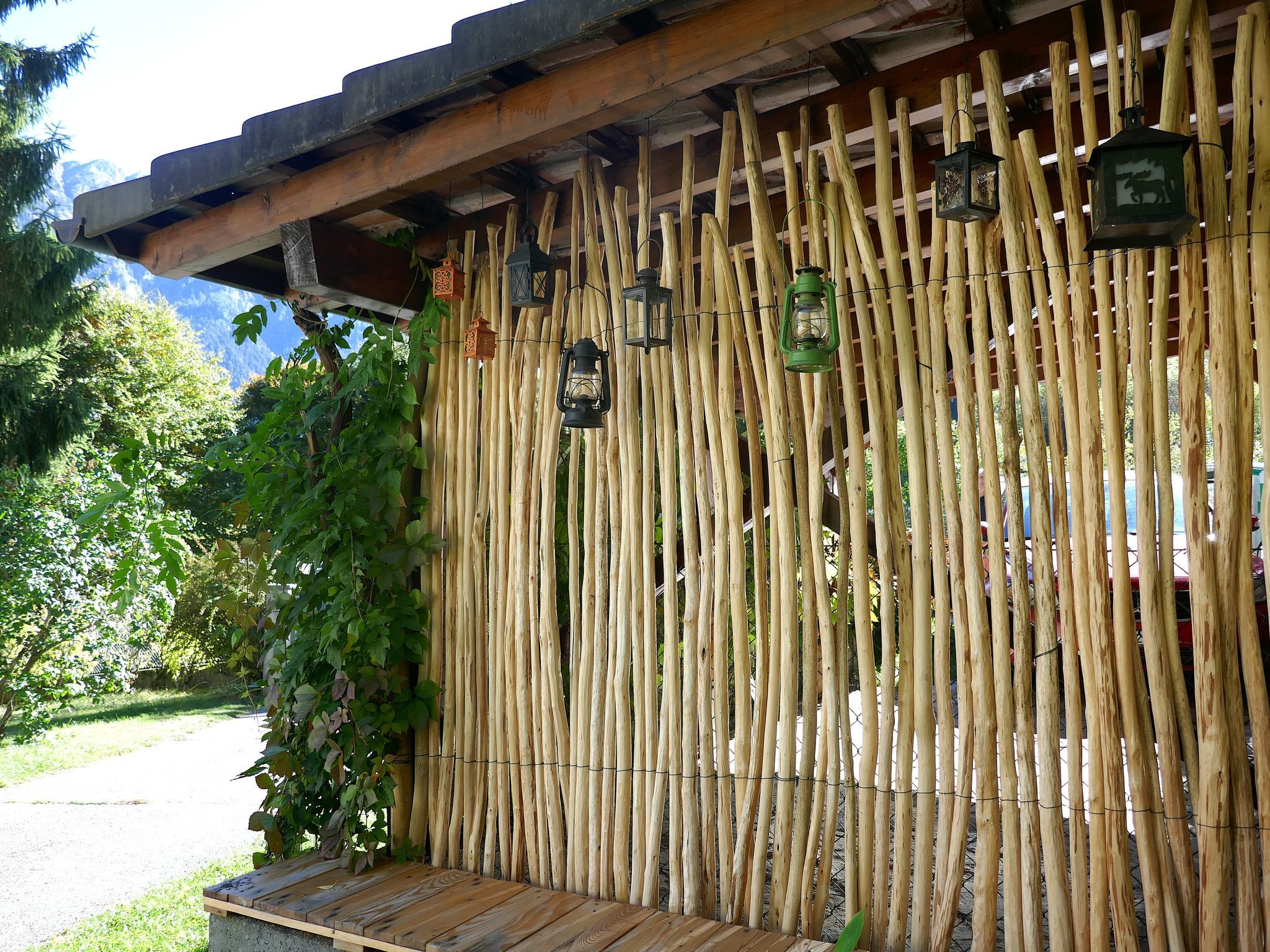 A bamboo fence with lanterns and a wooden deck.