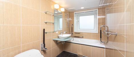 Un baño moderno con un lavabo de vidrio, un inodoro blanco y una zona de ducha.