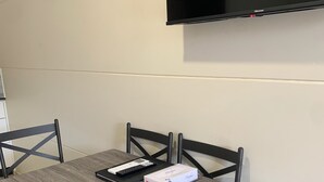 A conference room with a table, chairs, a flat-screen TV, and a box on the table. - Balranald Club Motel (Balranald)