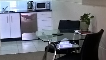 Cafetera o tetera, hervidor eléctrico y mesa de comedor