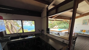 Eine Küche mit Blick auf einen Pool und Sitzgelegenheiten im Freien.