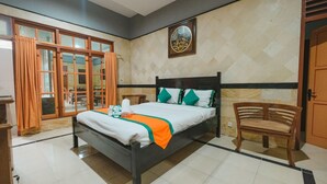 A hotel room with a bed, a wooden bench, a wall-mounted artwork, and a door. - Homestay Simply Homy Unit Gembiraloka (Yogyakarta)