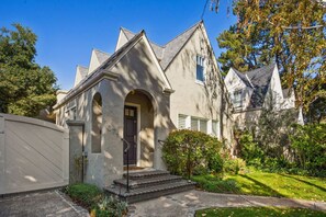 A two-story house with a stone facade, a dark front door, and a small front porch.